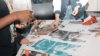 Close up of hands working on posters at a table