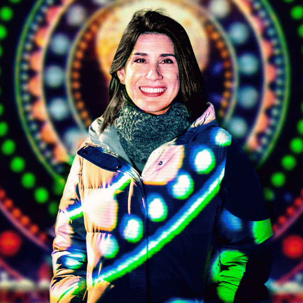 Photograph of Emma López Hechem, a Latinx woman wearing a black parka and thick gray scarf. She has straight shoulder length hair.