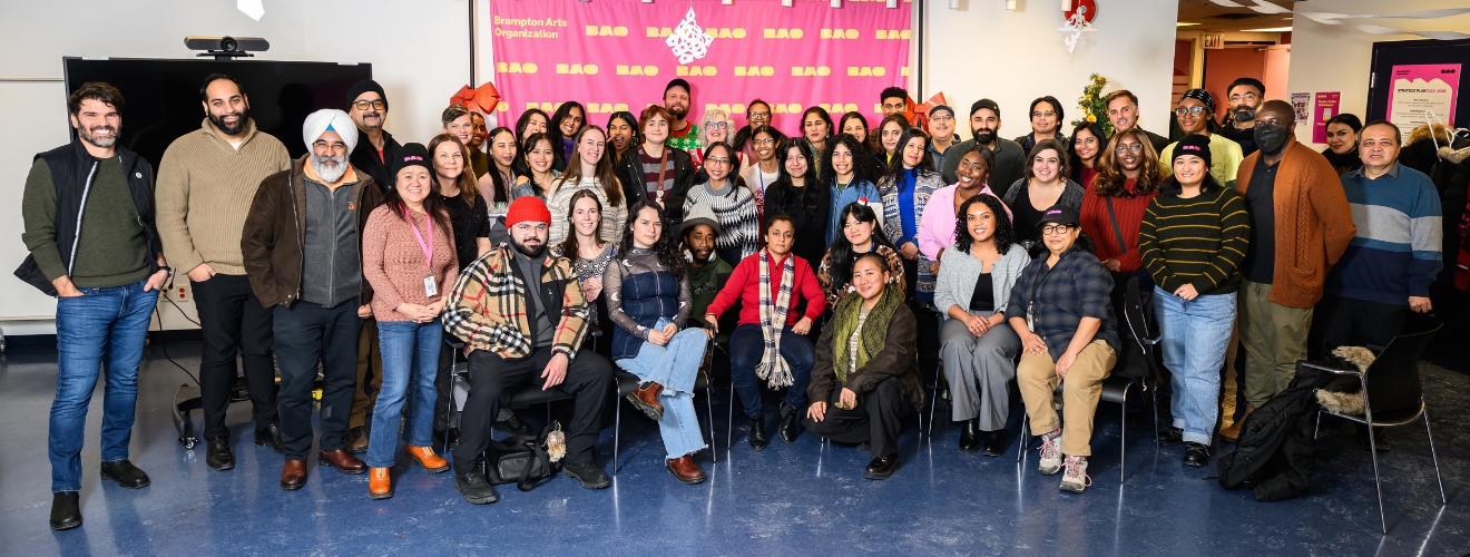 A large group of people standing together in a room to pose for a photo
