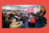 Photograph of a BAO Town Hall where the community members are looking at a presentation inside a red stylized B-shape