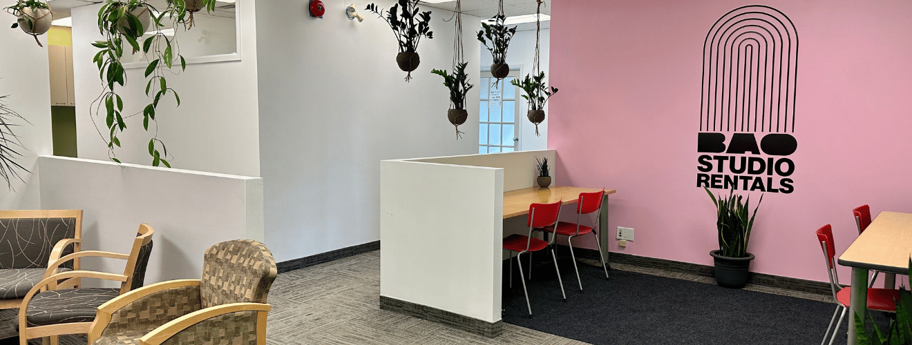 Photograph of the entrance to the BAO Studio Rentals. There are desks in front of a pink wall