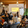 A diverse group of Brampton artists attending the 2025 Brampton Creative Leaders Summit in a cozy, well-lit room with wooden beams.