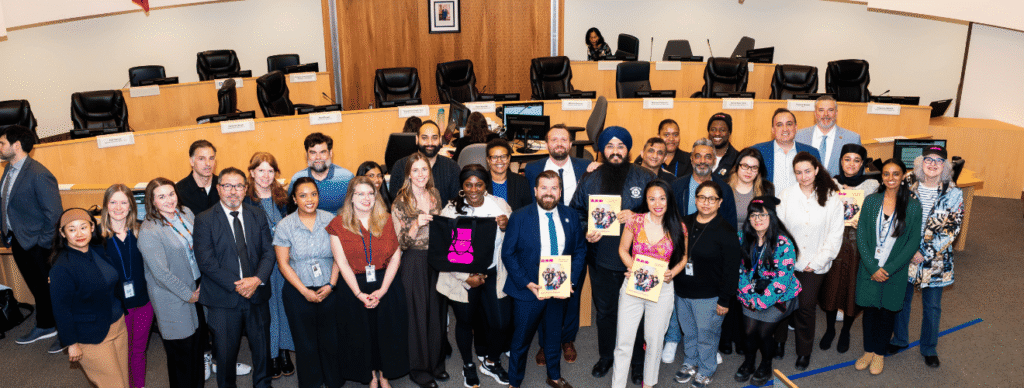 BAO staff and artists posing with the City of Brampton Councillors in chambers