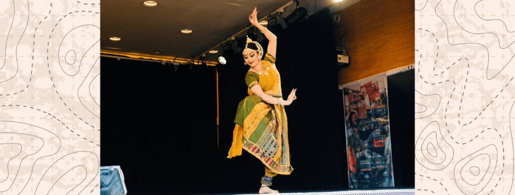 Photograph of a classical Indian dancer performing on a stage.