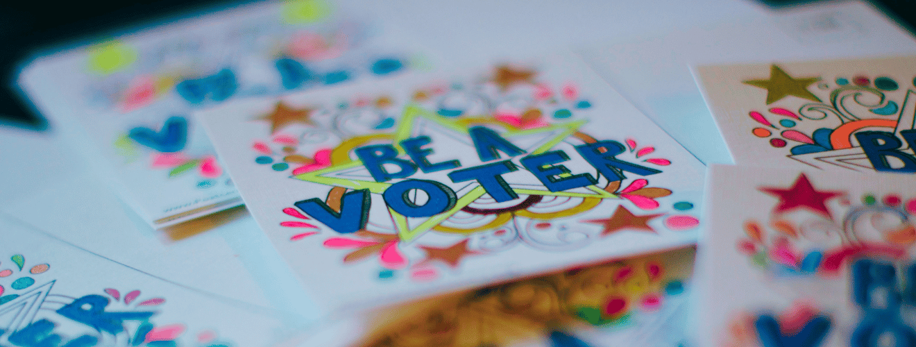 Photograph of colourful stickers that say, "BE A VOTER"